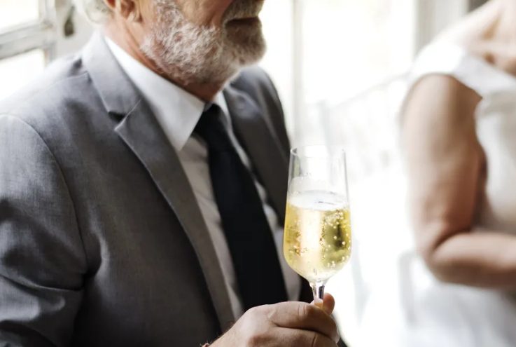 Op mijn bruiloft stond mijn biologische vader op en verklaarde dat hij mij de dag van mijn dromen had geschonken — maar de waarheid was dat de man die dat werkelijk mogelijk had gemaakt stil zat met een gebroken hart.